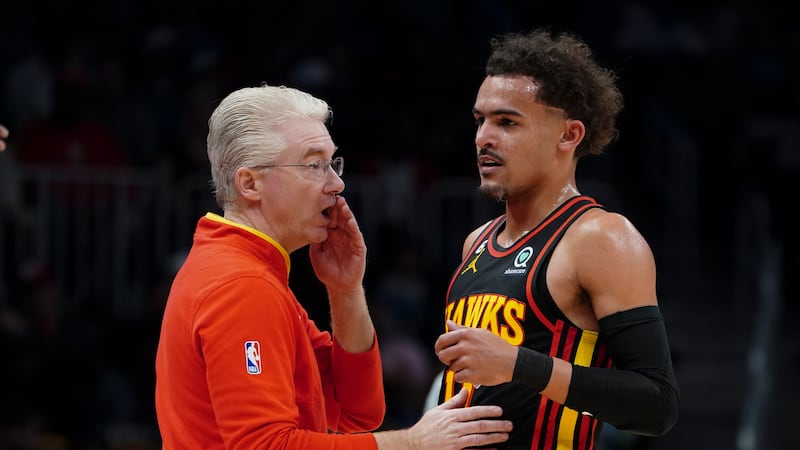 Atlanta Hawks interim head coach Joe Prunty, left, talks with guard Trae Young during the...