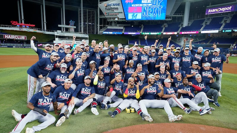 Atlanta Braves players pose for a photo after they clinched their fifth consecutive NL East...