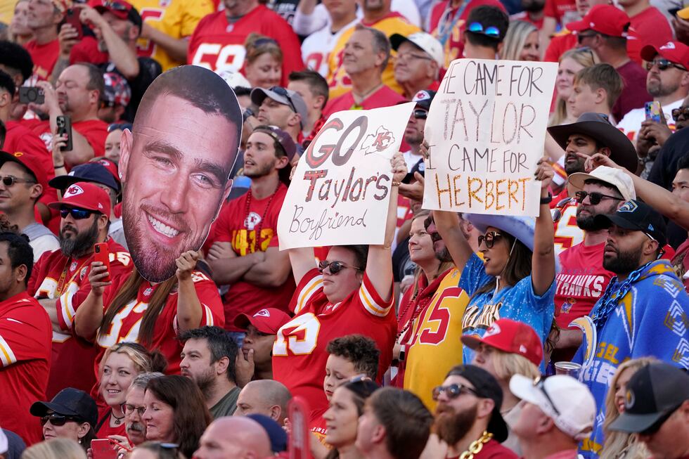 Fans hold sighs referring to Kansas City Chiefs tight end Travis Kelce (87) and Taylor Swift...