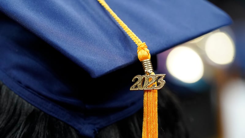 FILE - A tassel with 2023 on it rests on a graduation cap as students walk in a procession for...