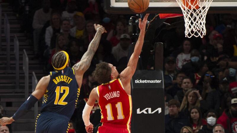 Atlanta Hawks guard Trae Young (11) scores past Indiana Pacers forward Oshae Brissett (12)...