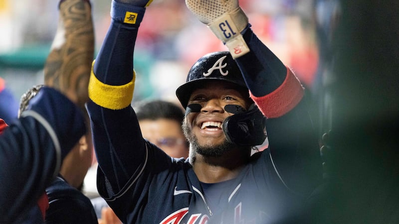 Atlanta Braves's Ronald Acuna Jr. celebrates in the dugout after scoring on an RBI single by...