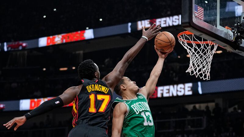 Boston Celtics' Malcolm Brogdon (13) scores against Atlanta Hawks' Onyeka Okongwu (17) during...